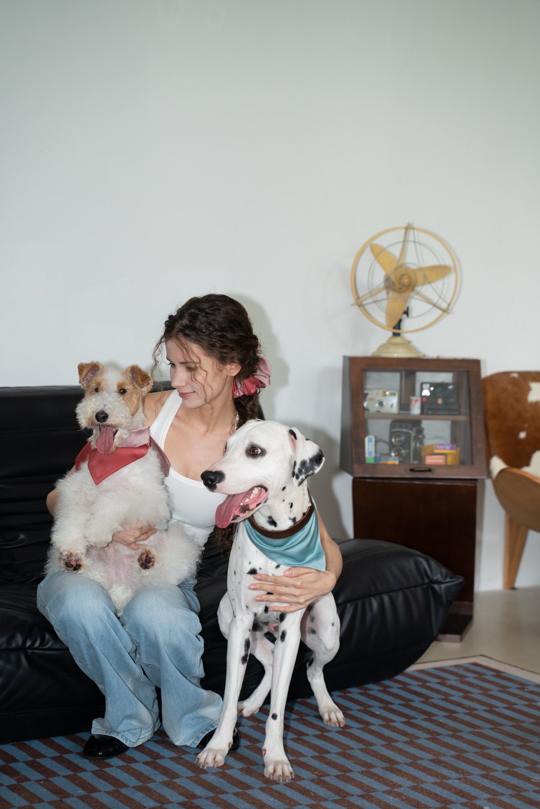 Woman with two dogs wearing coordinated satin bandanas and a matching scrunchie